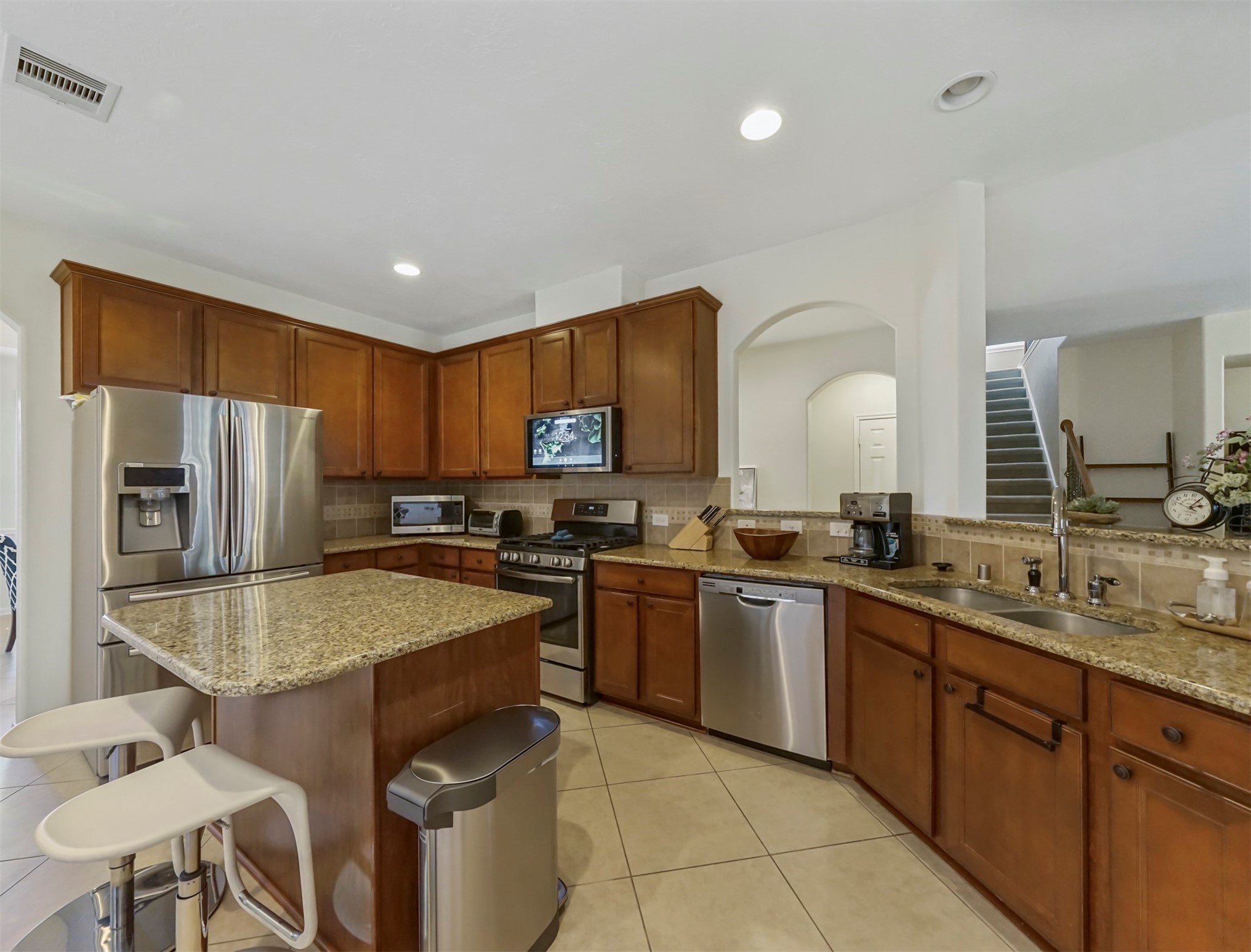8214 Garrison Point Drive Houston, TX 77040 - Photo 7 of 37 a kitchen with stainless steel appliances granite countertop a sink a stove a refrigerator and island