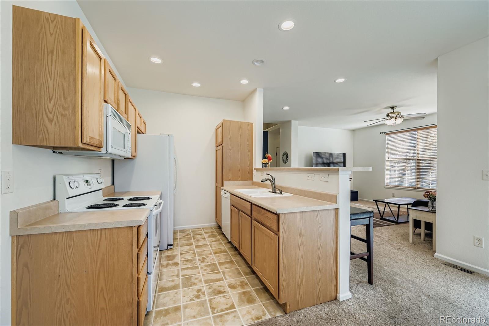 208 Remuda Lane Lafayette, CO 80026 - Photo 6 of 28 a kitchen with a sink a stove and a refrigerator