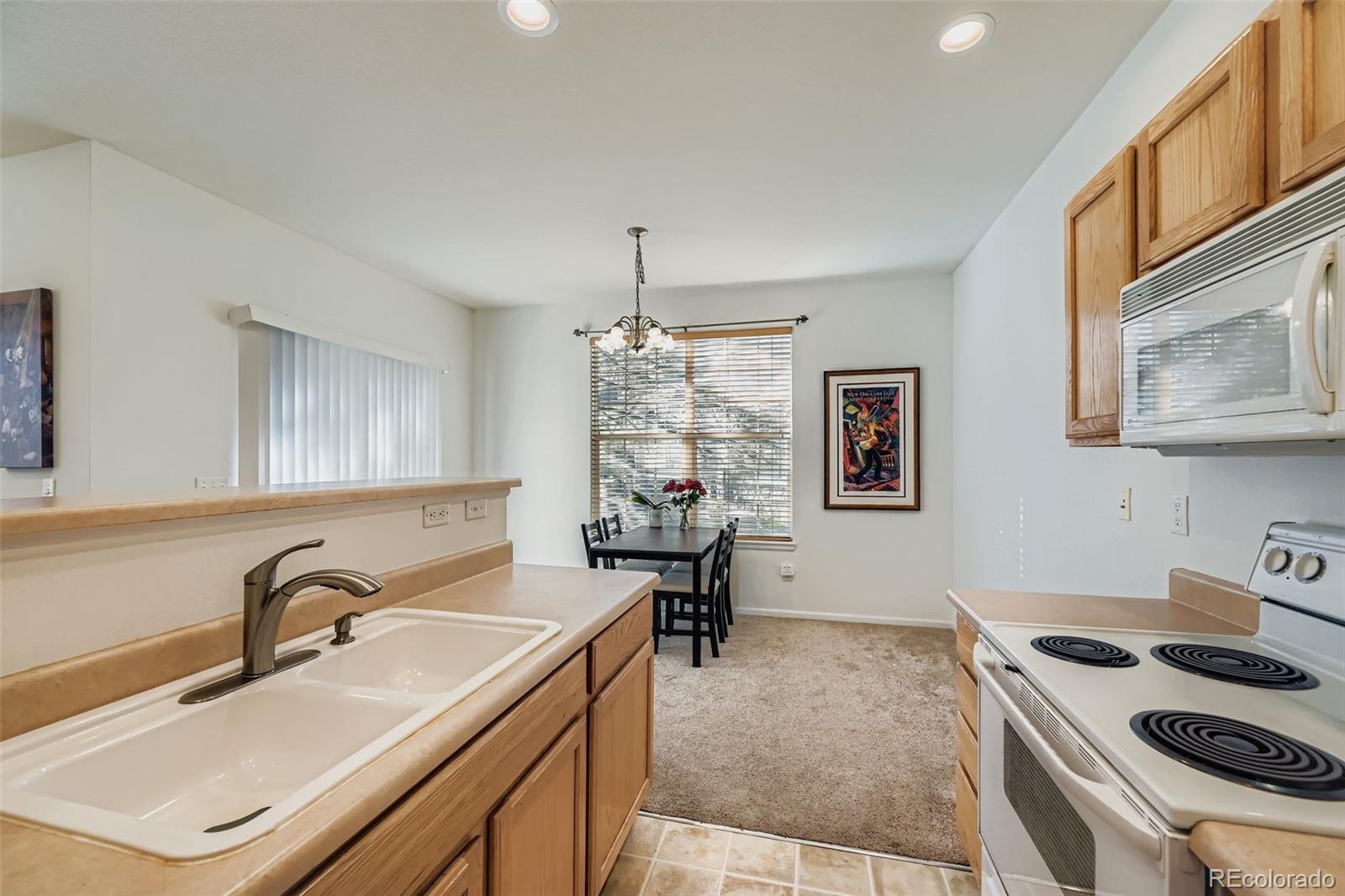208 Remuda Lane Lafayette, CO 80026 - Photo 7 of 28 a kitchen with a sink stove and cabinets