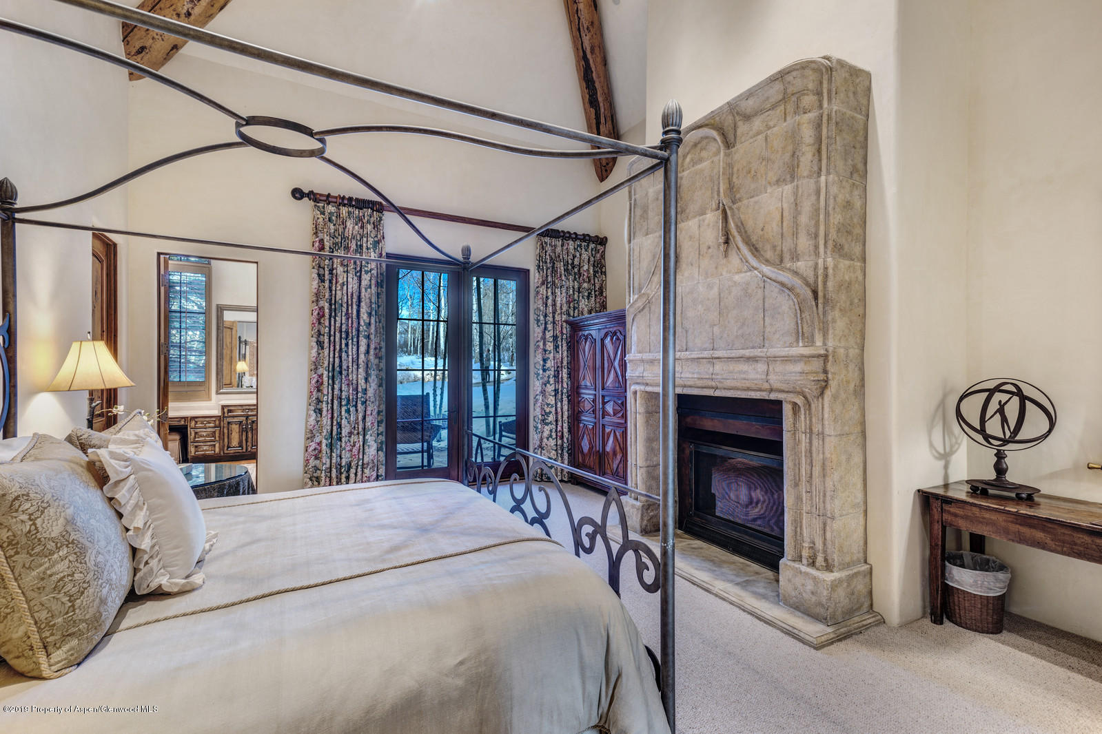 124 Cold Stream Lane Aspen, CO 81611 - Photo 26 of 38 a bedroom with a bed and a fireplace