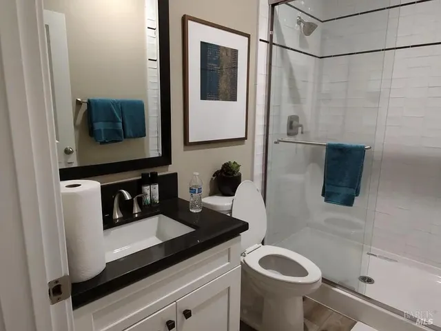a bathroom with a sink a toilet and shower