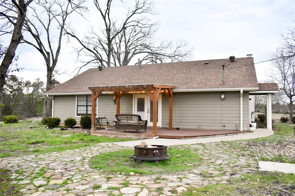 509 County Road 35985 Powderly, TX 75473 - Photo 12 of 37 a front view of a house with a garden and trees