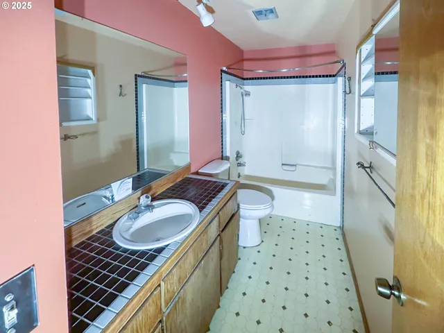 a bathroom with a sink a toilet a shower and a mirror