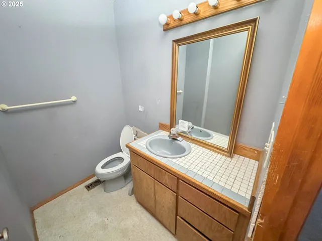 a bathroom with a sink a toilet and vanity