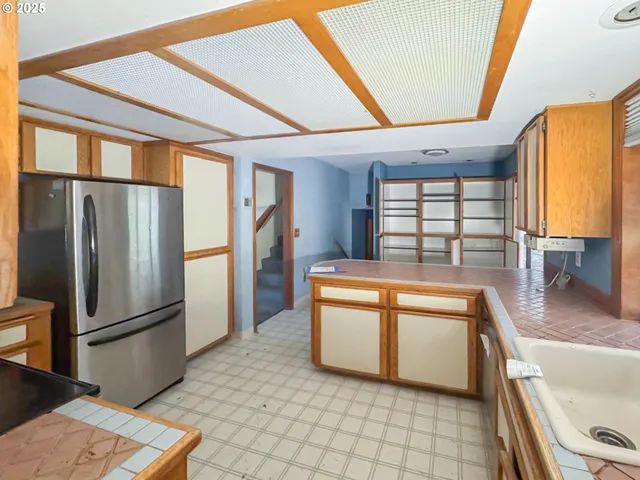 a kitchen with stainless steel appliances granite countertop a refrigerator a sink and white cabinets