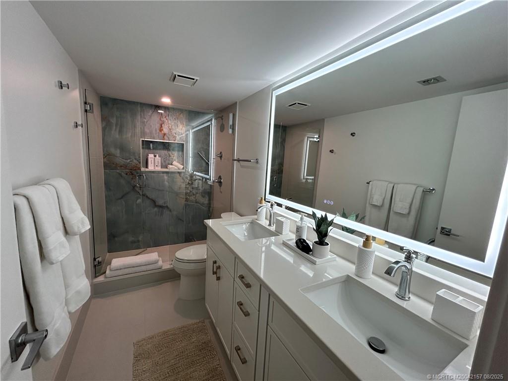 484 Northeast Plantation Road, Unit 4102 Stuart, FL 34996 - Photo 16 of 35 a bathroom with a sink a toilet a mirror and shower