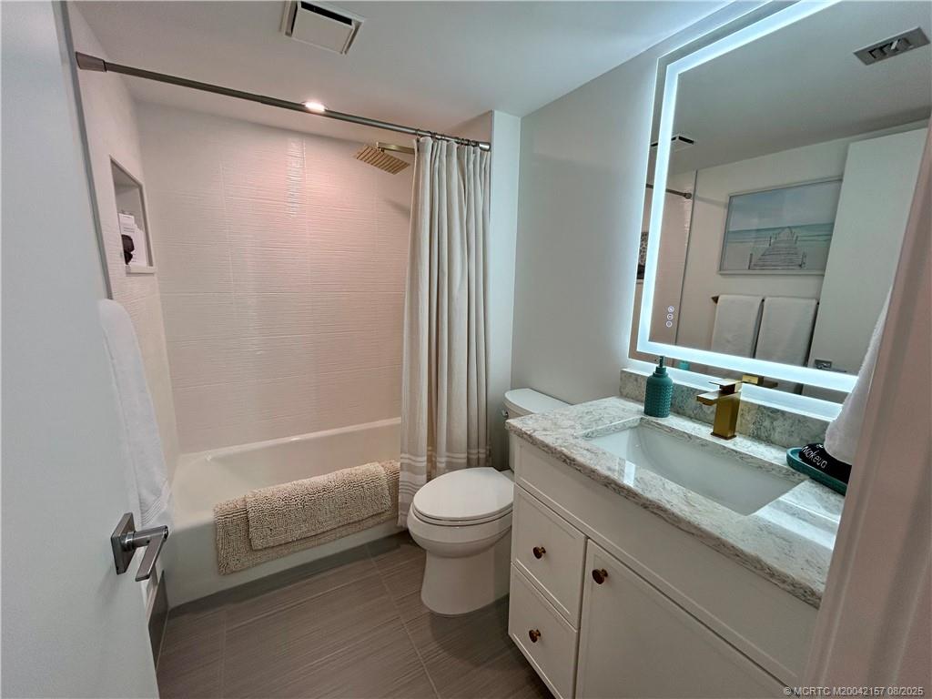 484 Northeast Plantation Road, Unit 4102 Stuart, FL 34996 - Photo 19 of 35 a bathroom with a granite countertop sink toilet and shower