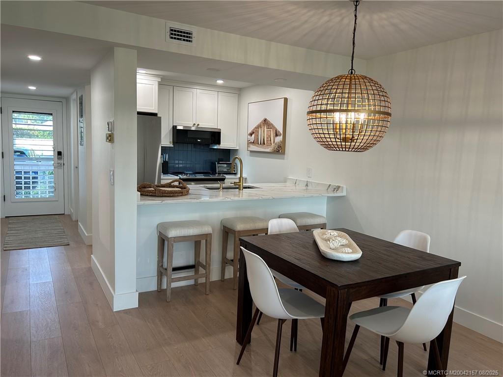 484 Northeast Plantation Road, Unit 4102 Stuart, FL 34996 - Photo 9 of 35 a view of kitchen and dining area with a sink wooden floor