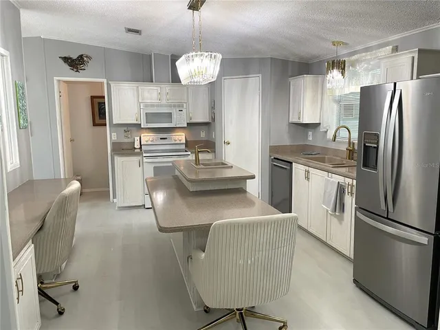 a kitchen with cabinets a sink stove and refrigerator