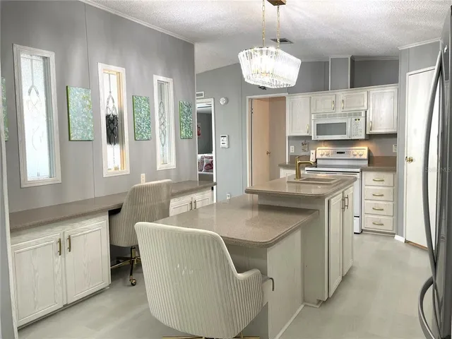 a kitchen with stainless steel appliances granite countertop a sink refrigerator and microwave