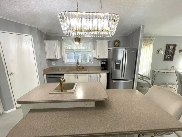 a large kitchen with granite countertop a sink dishwasher a stove and a dining table with wooden floor