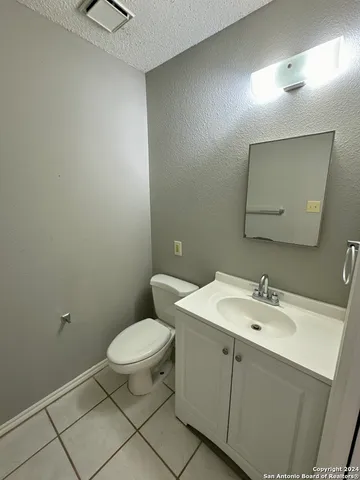 a bathroom with a toilet a sink and mirror