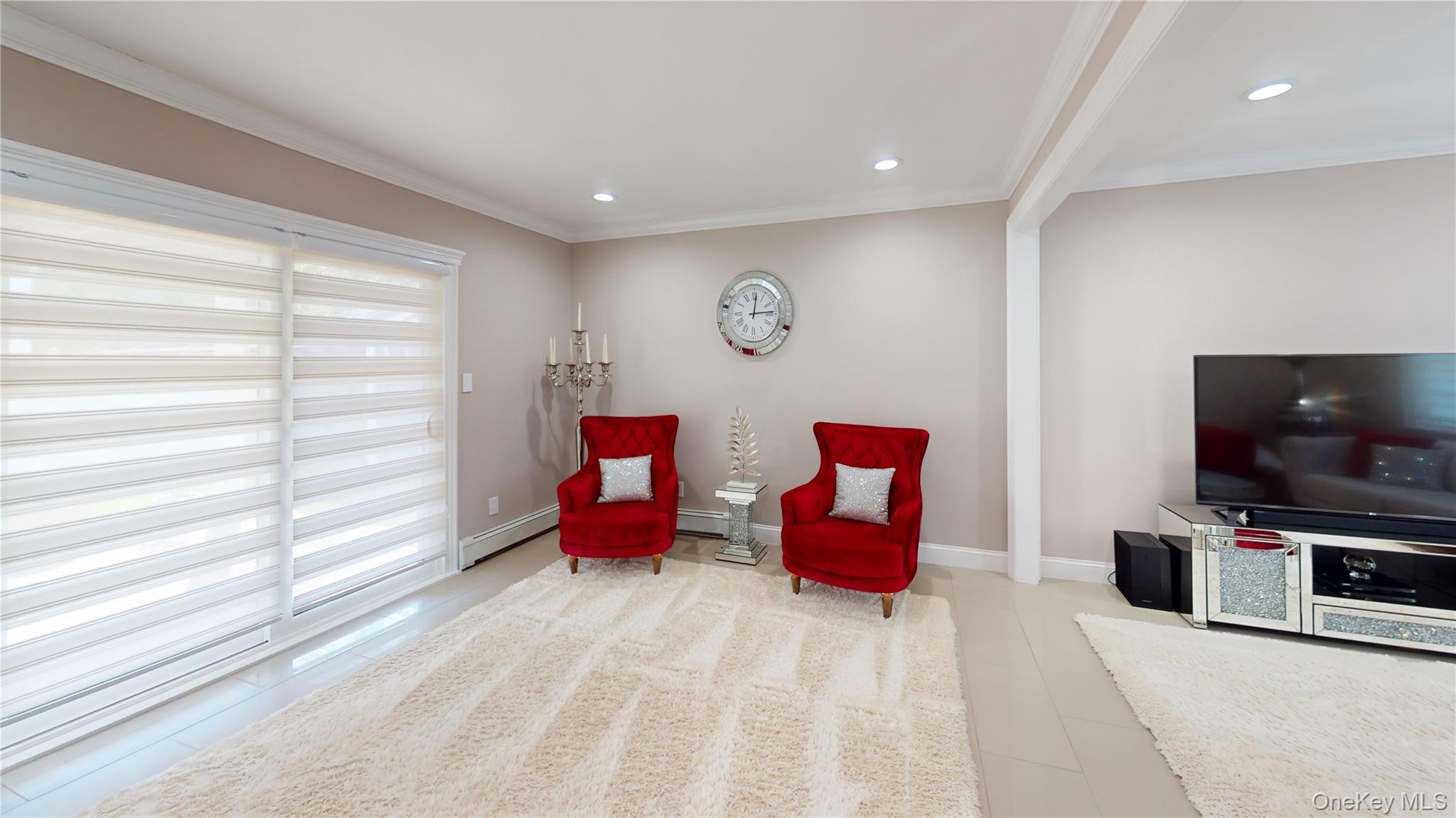 125 Spruce Street Lindenhurst, NY 11757 - Photo 20 of 29 Living area featuring a baseboard heating unit, crown molding, recessed lighting, and beam ceiling