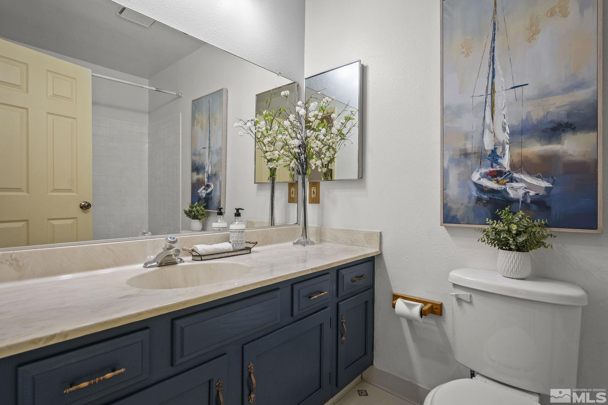 1958 Fieldcrest Drive Sparks, NV 89434 - Photo 17 of 22 a bathroom with a granite countertop sink a toilet and a mirror