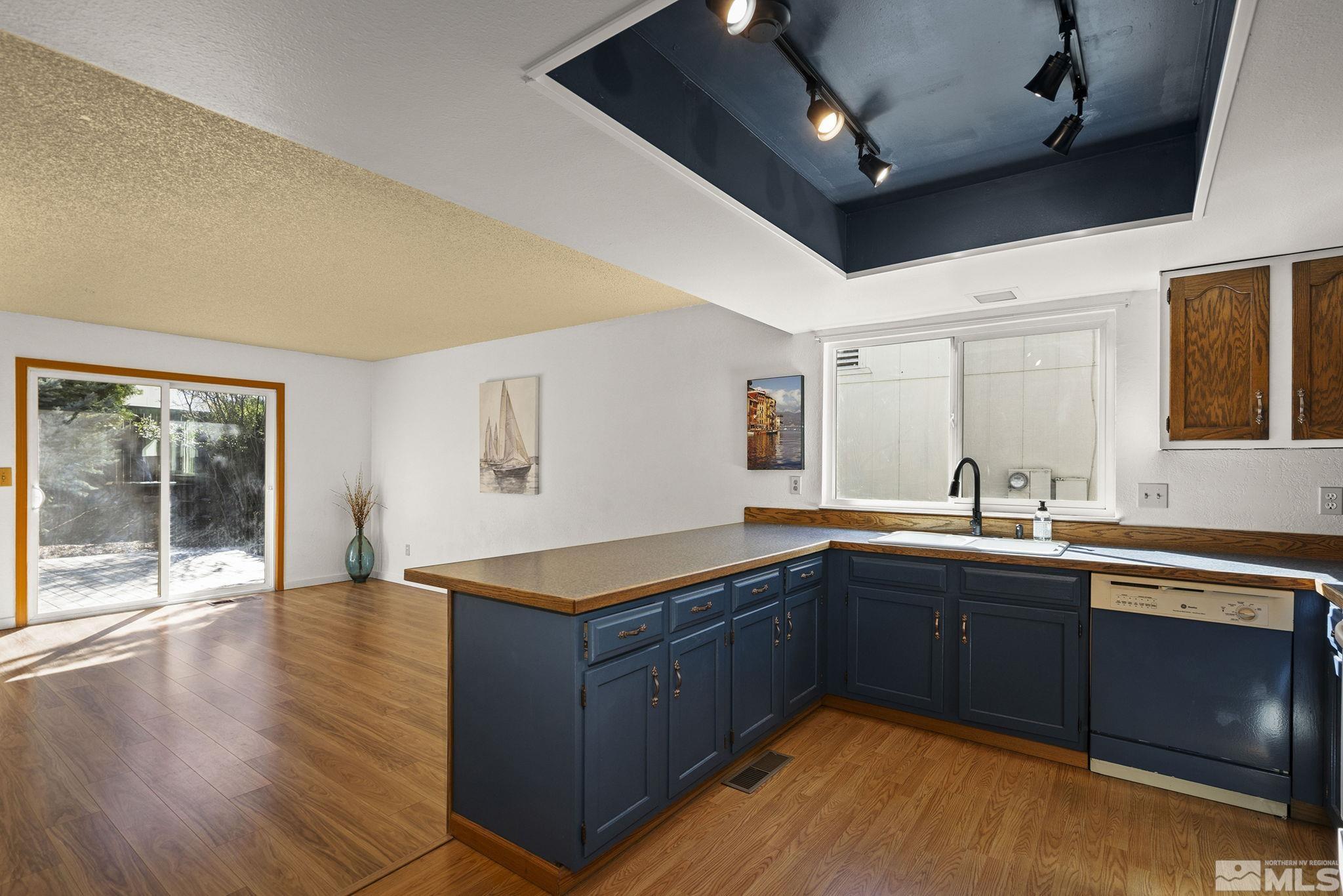 1958 Fieldcrest Drive Sparks, NV 89434 - Photo 7 of 22 a kitchen with stainless steel appliances granite countertop a sink dishwasher stove and wooden cabinets with wooden floor