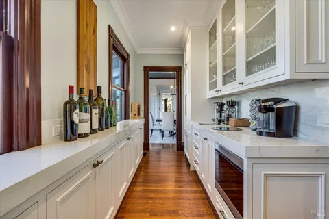 a kitchen with stainless steel appliances granite countertop a stove a sink a oven a dining table and chairs with wooden floor