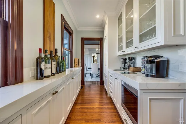 a kitchen with stainless steel appliances granite countertop a stove a sink a oven a dining table and chairs with wooden floor