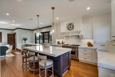 a kitchen with stainless steel appliances granite countertop a stove and a white cabinets
