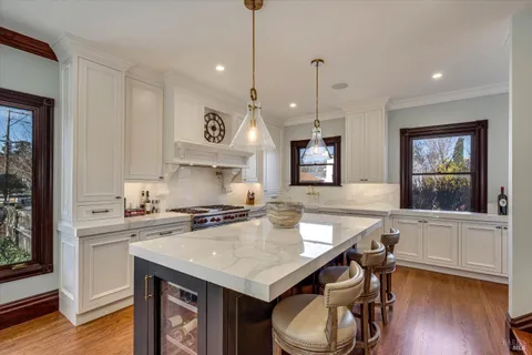 a kitchen with a stove and wooden floor
