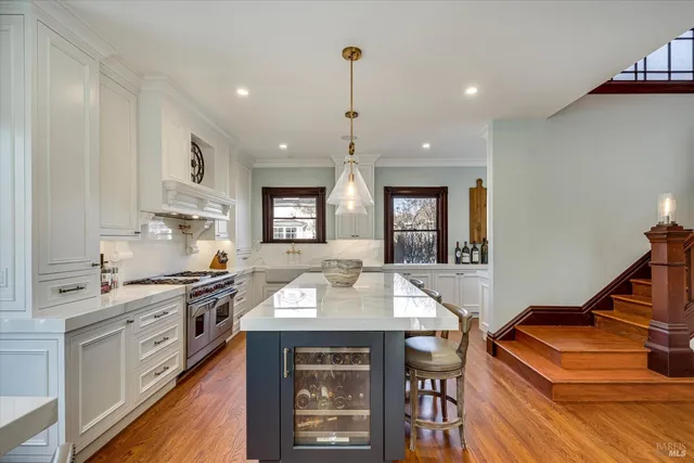 a living room with couches a fireplace and a chandelier