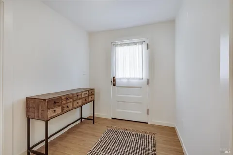 a kitchen with stainless steel appliances granite countertop a stove top oven a sink dishwasher a dining table and chairs with wooden floor