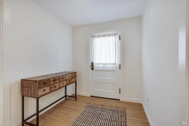 a kitchen with stainless steel appliances granite countertop a stove top oven a sink dishwasher a dining table and chairs with wooden floor