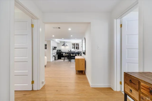a kitchen with stainless steel appliances kitchen island a table and chairs in it