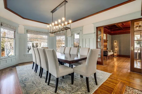 a large white kitchen with granite countertop a sink and dishwasher a stove with wooden floor