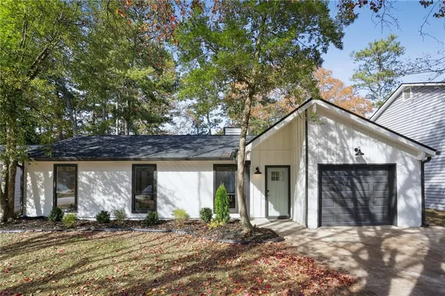 a front view of a house with a tree in front