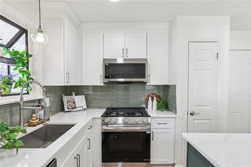 5457 Rails Way Norcross, GA 30071 - Photo 11 of 30 a kitchen with a stove and a white cabinets