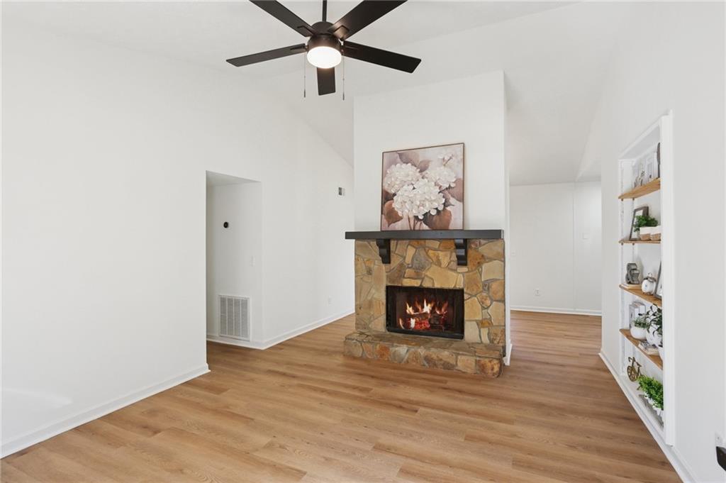 5457 Rails Way Norcross, GA 30071 - Photo 3 of 30 an empty room with wooden floor a fireplace and a window