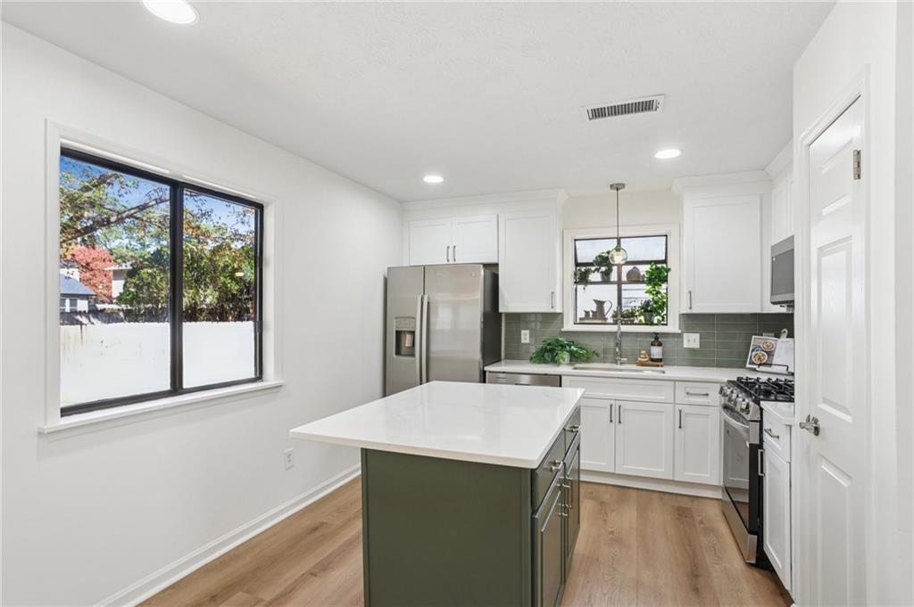 5457 Rails Way Norcross, GA 30071 - Photo 9 of 30 a kitchen with a sink a counter top space stainless steel appliances cabinets and a large window
