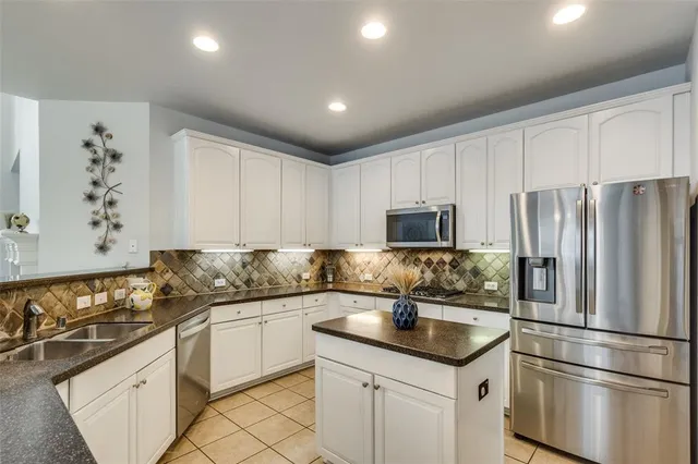 a kitchen with granite countertop a sink stainless steel appliances and cabinets