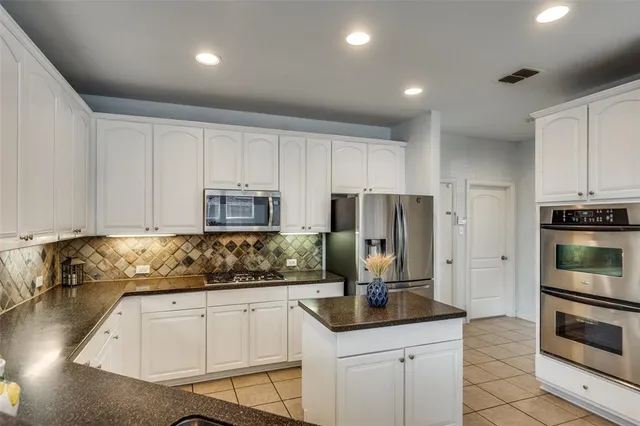a kitchen with stainless steel appliances granite countertop a refrigerator sink and stove