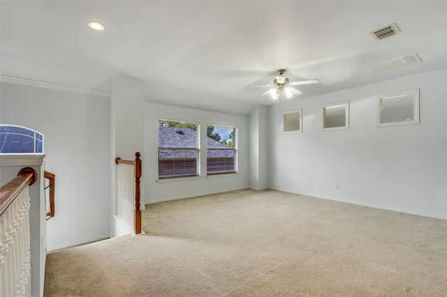 a big room with chandelier fan and windows