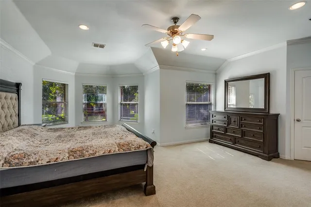 a spacious bedroom with a large bed and a chandelier
