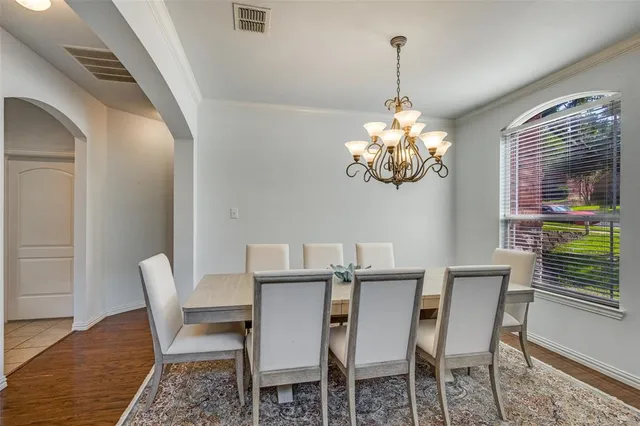 a dining room with furniture a chandelier and wooden floor