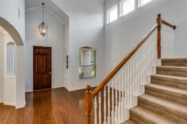 a view of staircase with lots of frames on wall and wooden floor