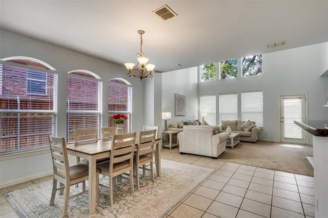 a dining room with furniture a chandelier and window