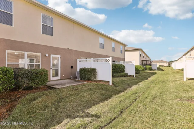 a view of a house with backyard and trees