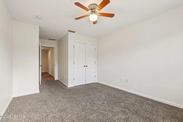 a view of a room with a ceiling fan and a window