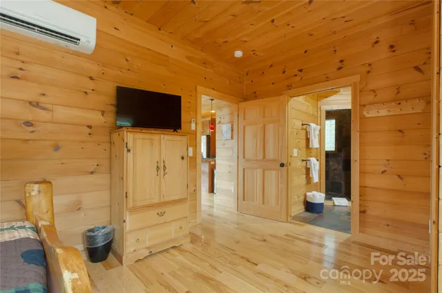 a view of a livingroom with wooden floor and a bathroom