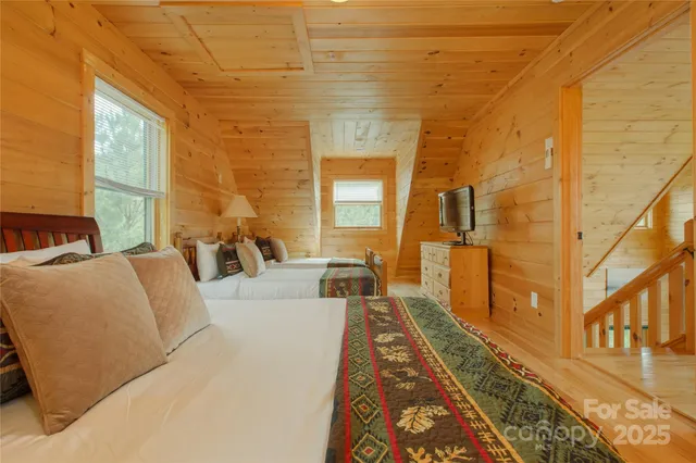 a spacious bedroom with a bed and flat screen tv