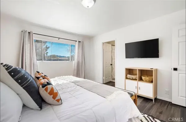 a bedroom with a bed and a flat screen tv