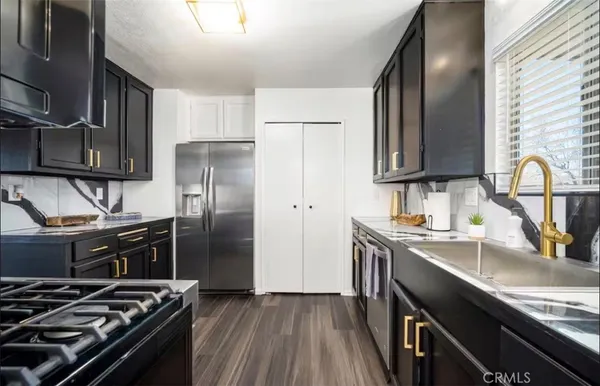 a kitchen with wooden cabinets stainless steel appliances and a sink