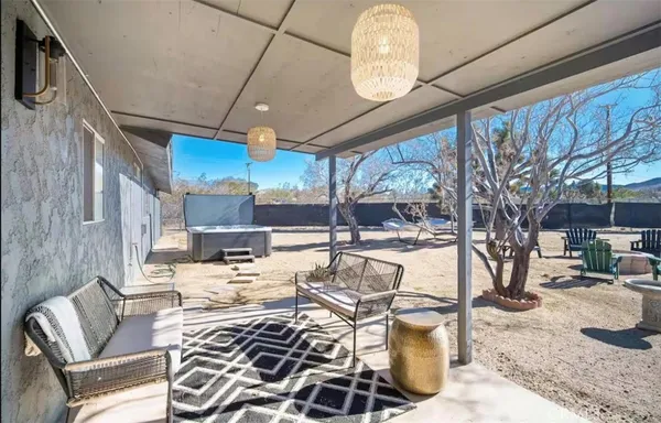 a view of a dining room with furniture a chandelier and large windows