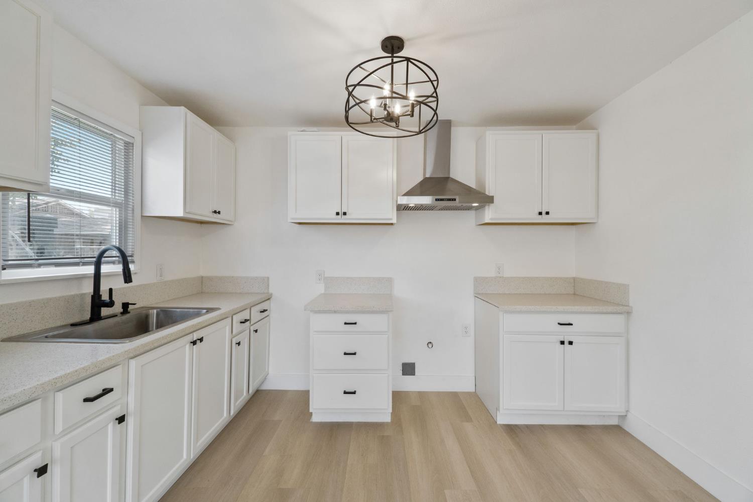 1559 North Carruth Avenue Fresno, CA 93728 - Photo 12 of 24 a kitchen with white cabinets and a clock on the wall