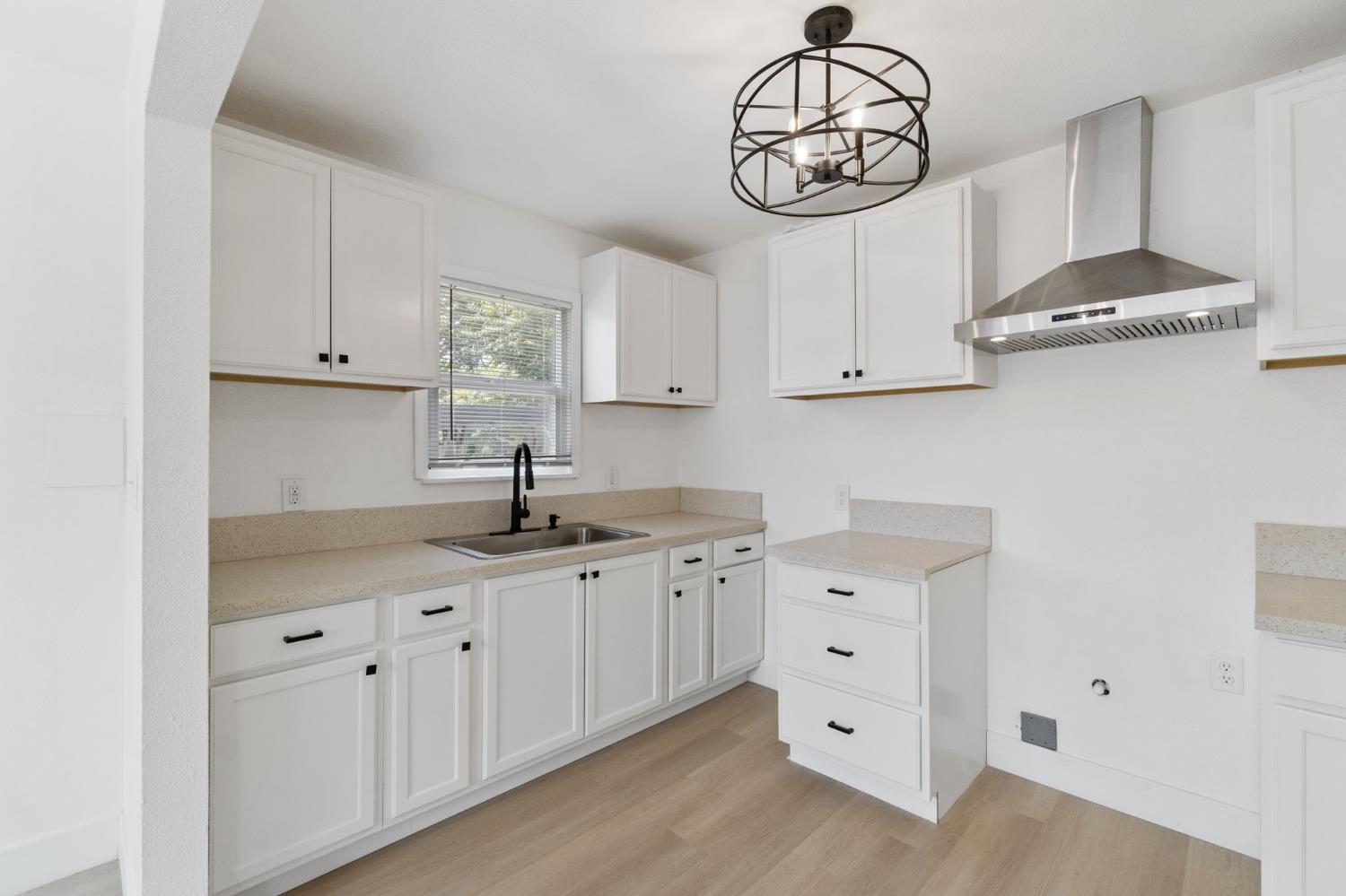 1559 North Carruth Avenue Fresno, CA 93728 - Photo 13 of 24 a kitchen with white cabinets and a sink