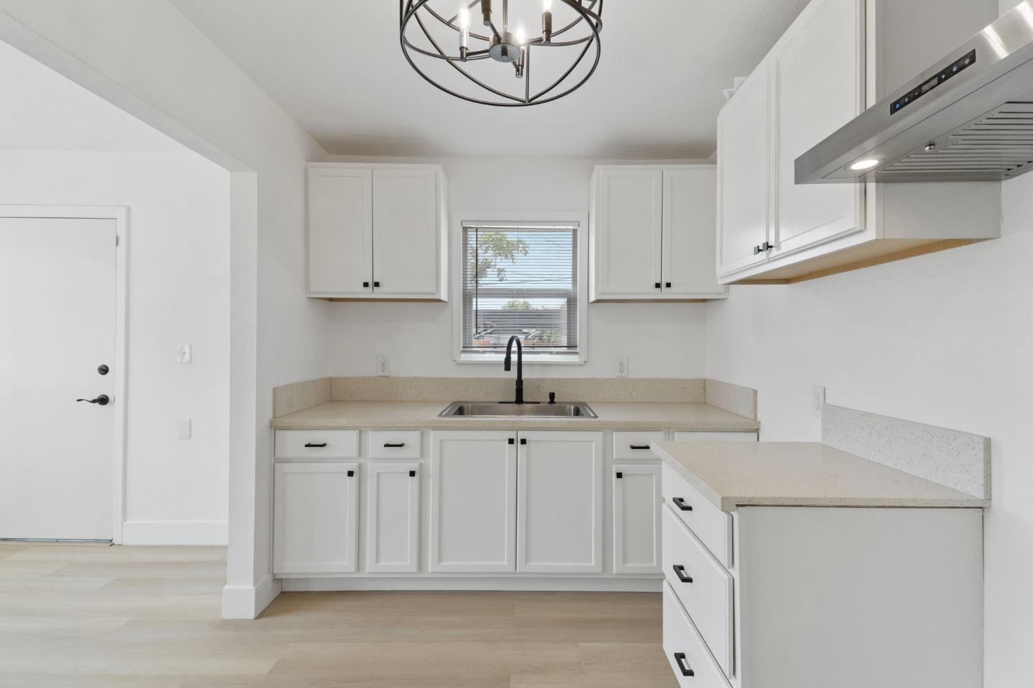 1559 North Carruth Avenue Fresno, CA 93728 - Photo 14 of 24 a kitchen with white cabinets and a sink