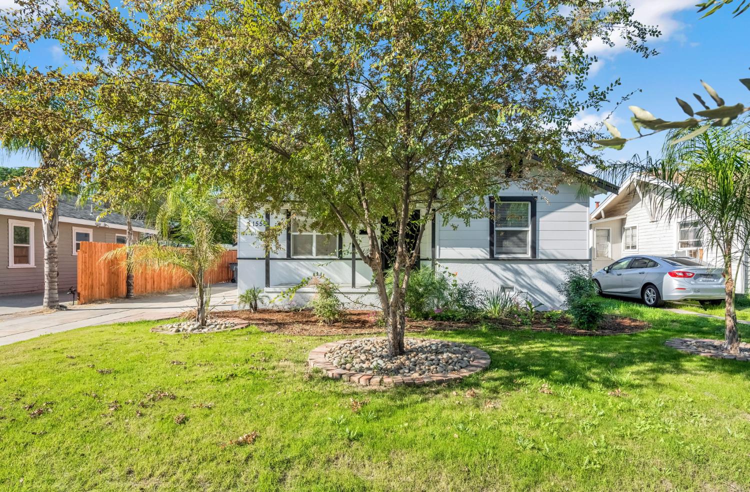 1559 North Carruth Avenue Fresno, CA 93728 - Photo 2 of 24 a backyard of a house with plants and large tree